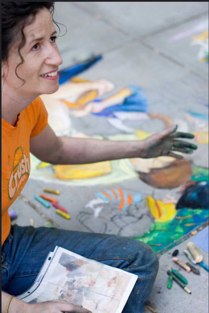 Dana Ellyn smiling while working on her chalk recreation of Renoir's Luncheon of the Boating Party outside The Phillips Collection